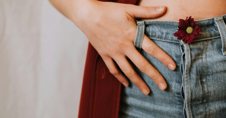 Woman holding her jean belt loop