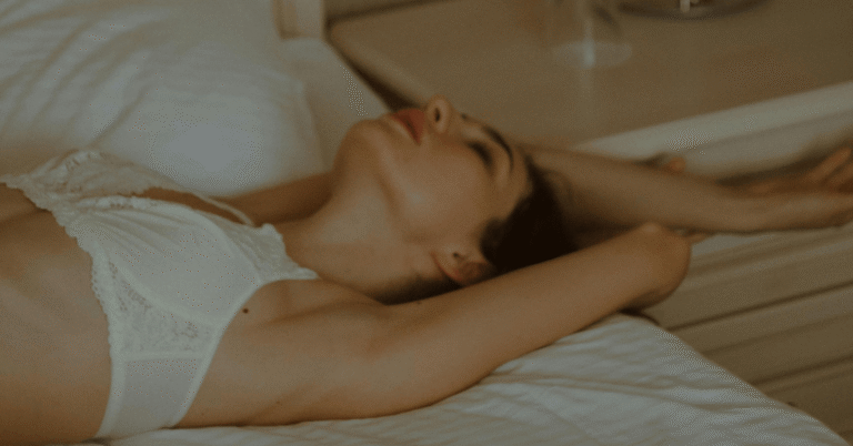 A blonde haired woman laying in bed.