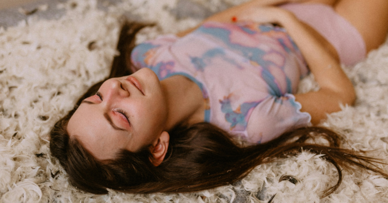 A woman lying down and holding her stomach