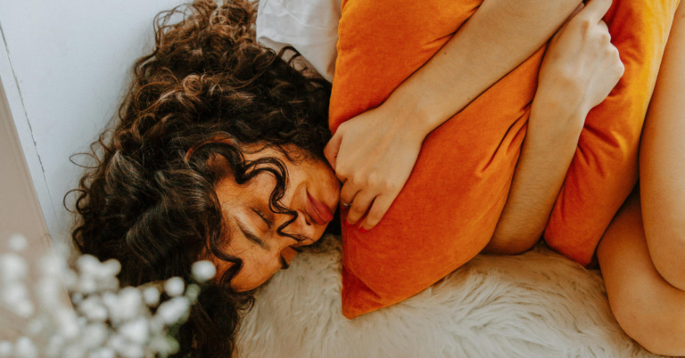 Woman holding an orange pillow